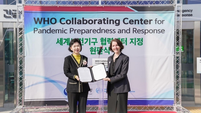 지영미 질병관리청장(왼쪽)이 30일 열린 ‘팬데믹 대비·대응 WHO 협력센터’ 현판식에서 지나 사만 세계보건기구 서태평양지역사무처 위기국장으로부터 WHO 협력센터 지정서를 받고 있다. /질병관리청 제공