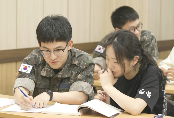  KT희망나눔인상 공동 수상자인 공군 제15특수임무비행단 교육봉사 동아리 소속 장병이 멘토링 학생을 가르치고 있다. 사진 | KT